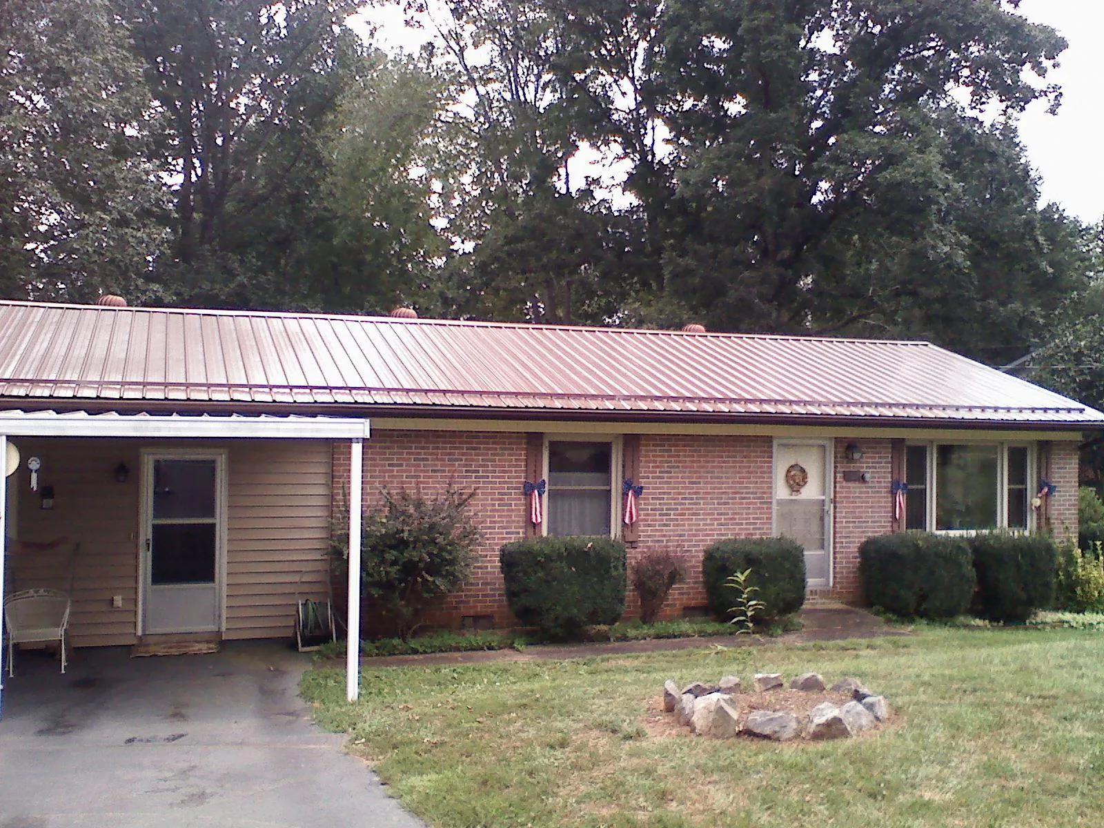 Bronze metal roof and carport on a brick ranch home — Roof Repair work by our crew in Louisville